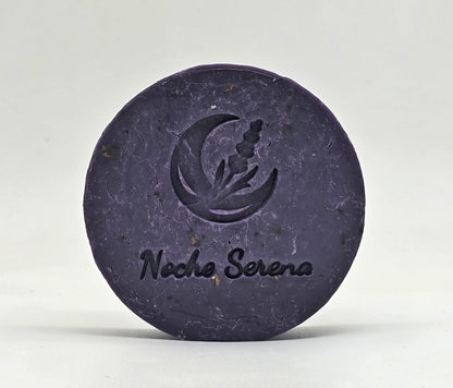 Jabón artesanal de lavanda Noche Serena con el sello de luna y lavanda grabado, sobre fondo gris claro